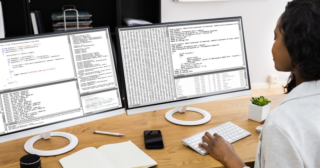 "Image depicting a person at a desk comparing various medical billing software options on multiple screens. The person is considering factors like cost, features, user interface, customer support, and compatibility. Speech bubbles above the person's head contain keywords related to the decision-making process."